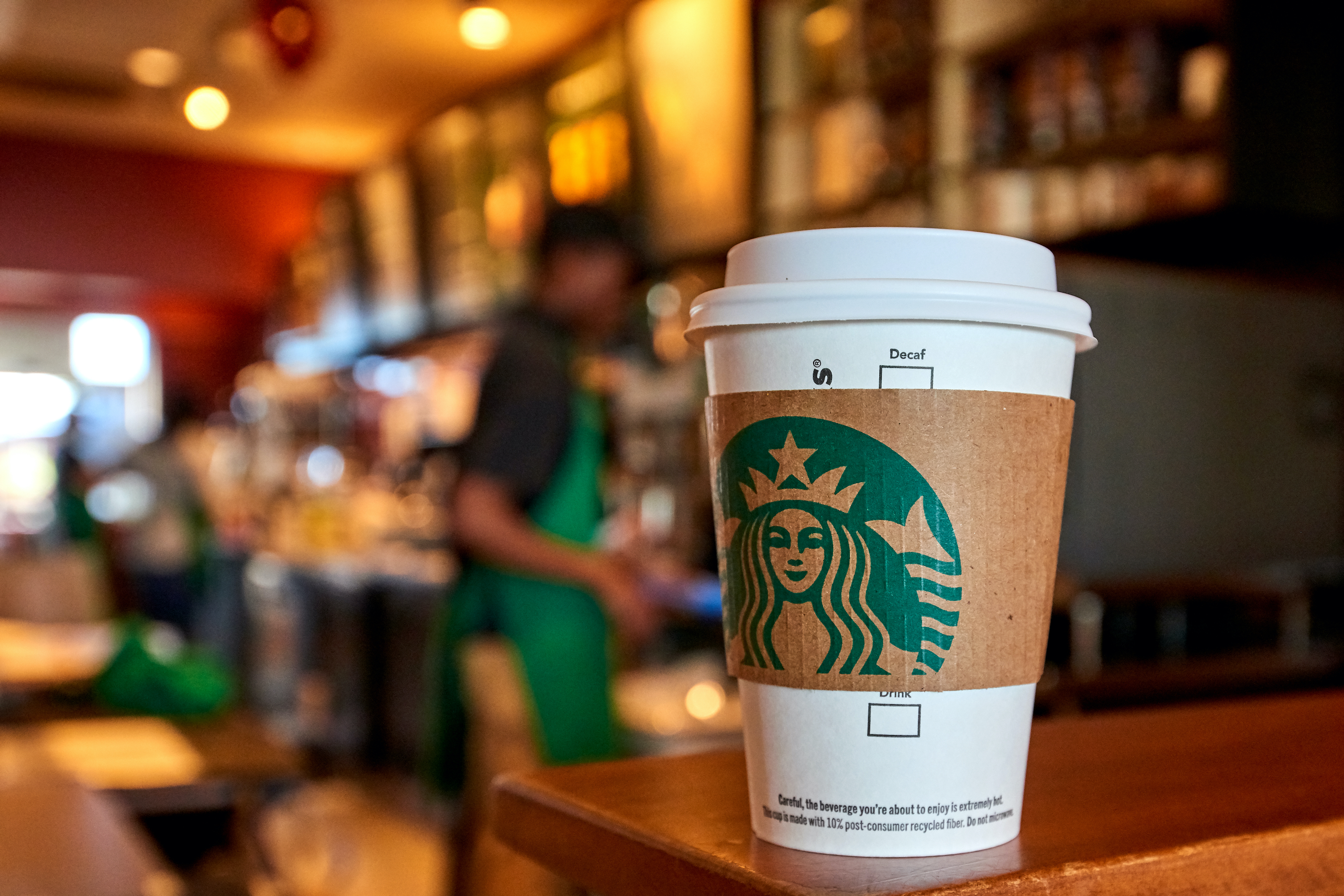 A Starbucks cup sitting on a counter inside of a store.