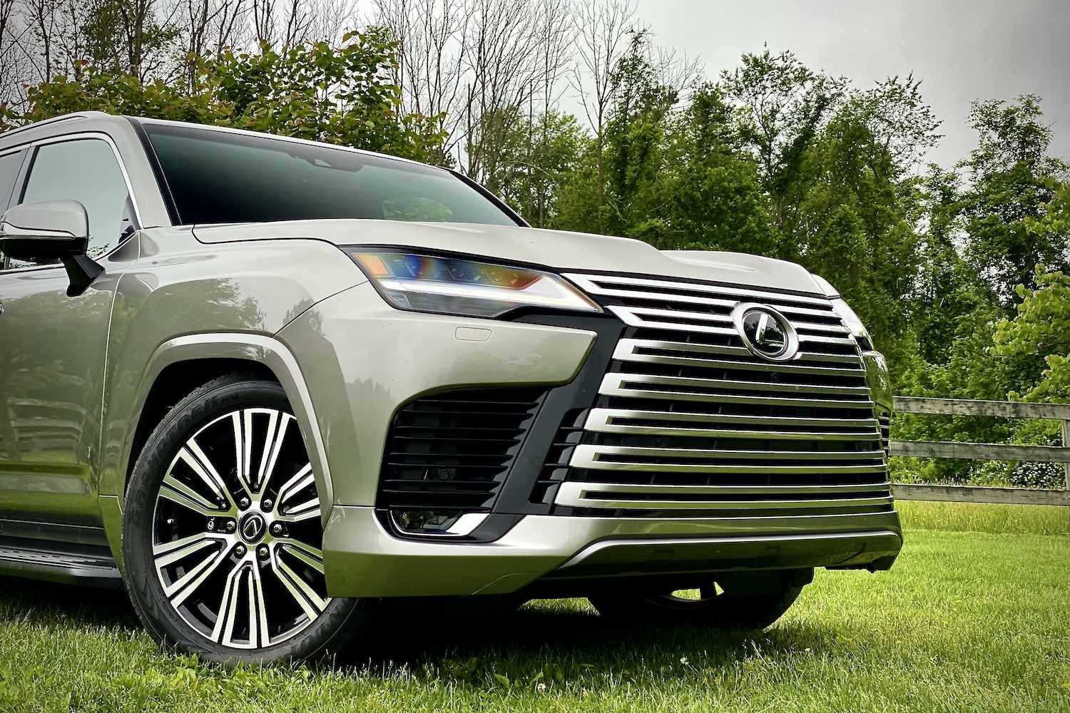 2022 Lexus LX 600 close up of front end with trees in the back on a grassy field.