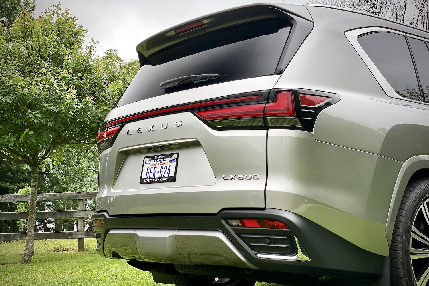 Close up of rear end on 2022 Lexus LX 600 with green trees in the back.