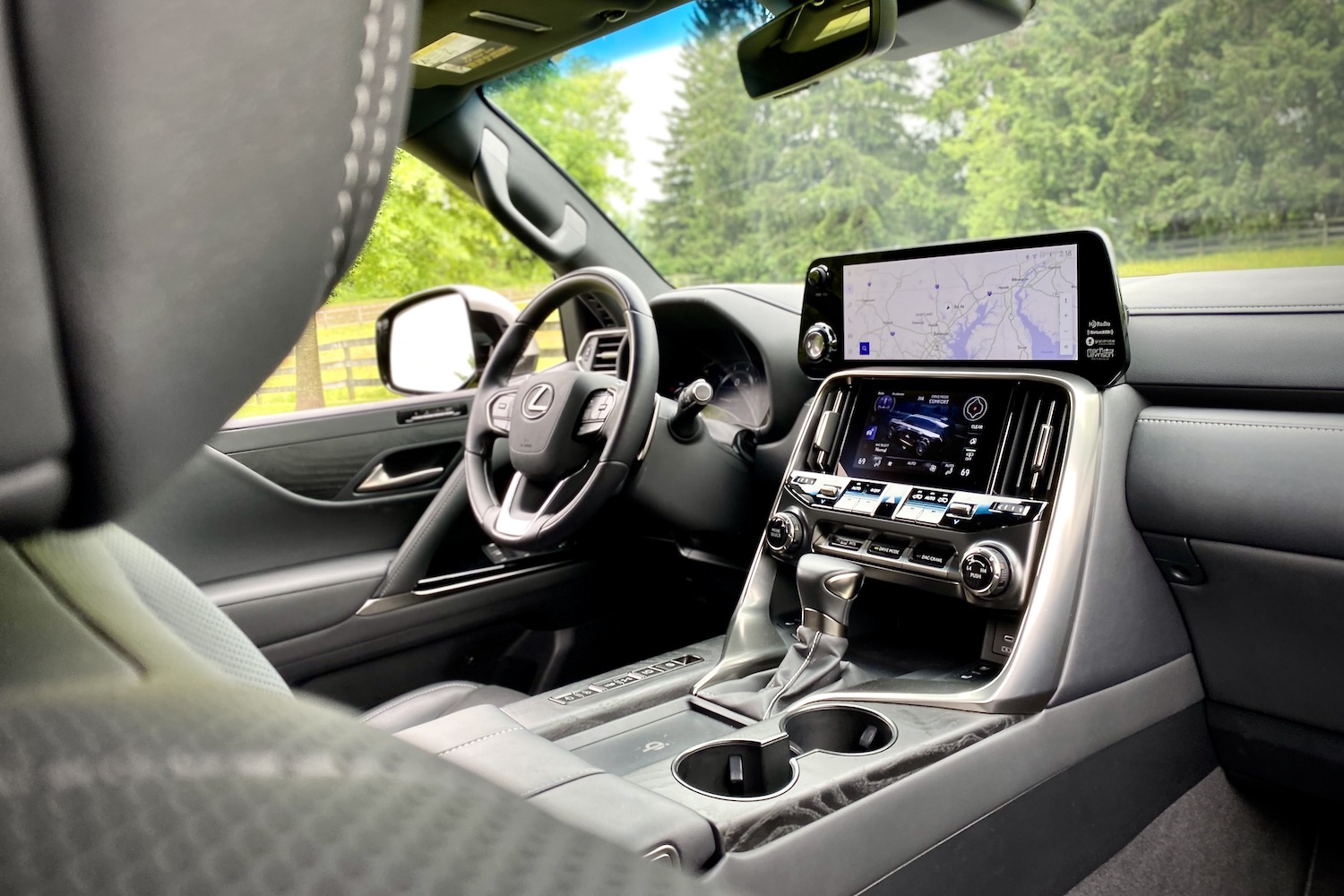 2022 Lexus LX 600 dashboard and steering wheel from passenger's side with trees in the back.