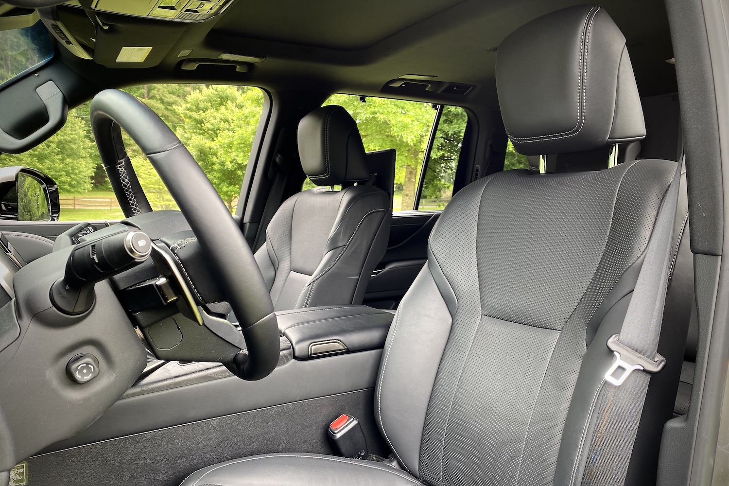 Front seats in the 2022 Lexus LX 600 with trees in the back.