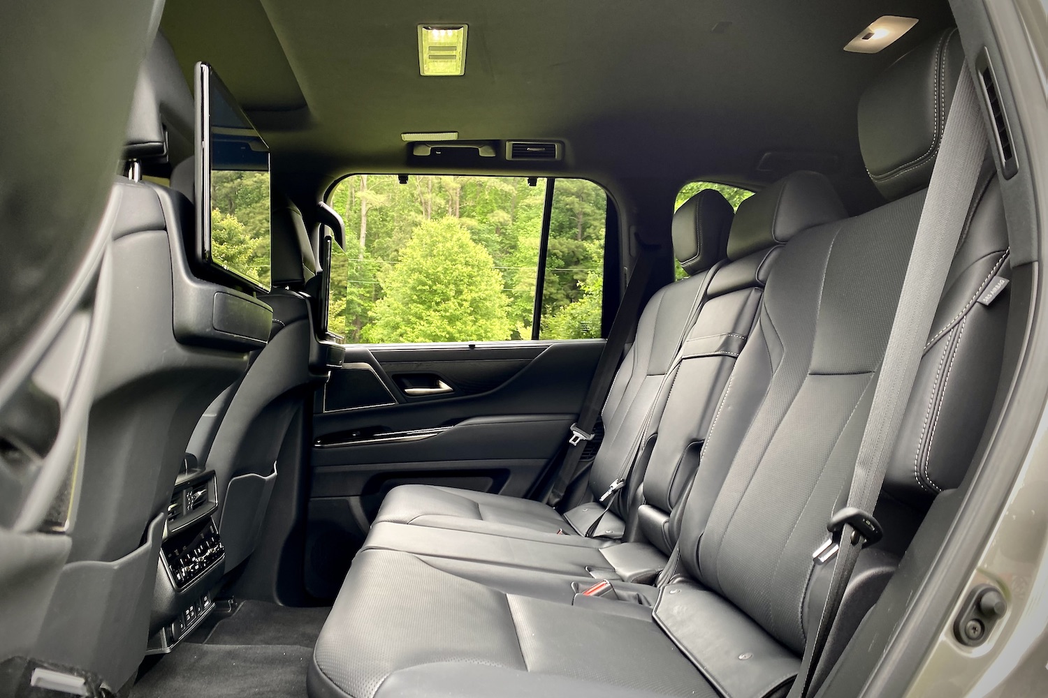 Second-row seats in the 2022 Lexus LX 600 from the driver's side with trees in the back.