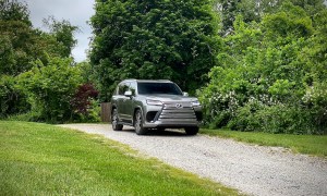 2022 Lexus LX 600 front end angle from the passengers side on a gravel trail with trees in the back.