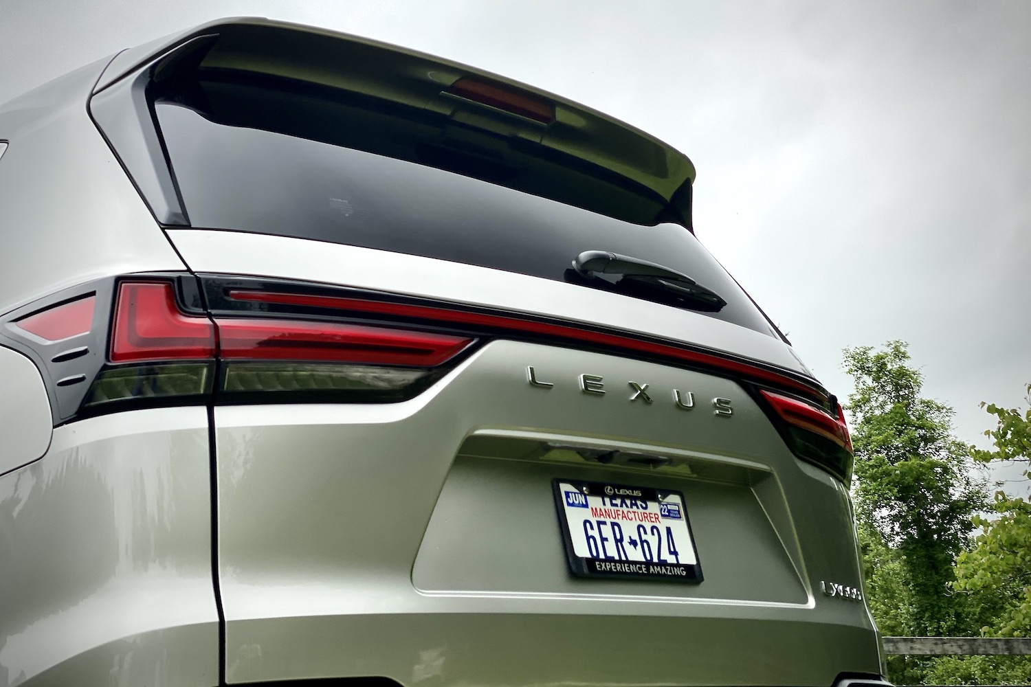 Rear end close up of 2022 Lexus LX 600 rear end badge and lightning with gray skies in the back.