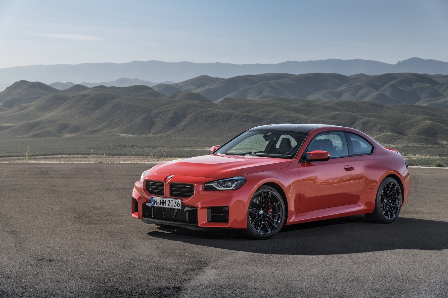 2023 BMW M2 front end angle from the driver's side with mountains in the back.