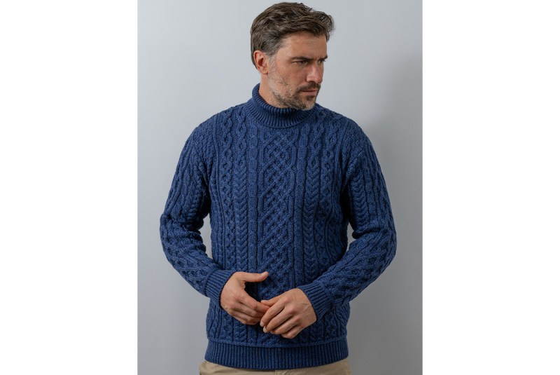 Man wearing a blue cable knit turtleneck sweater.