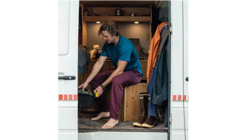 A man sitting in his van in a pair of maroon Ibex Nomad Joggers