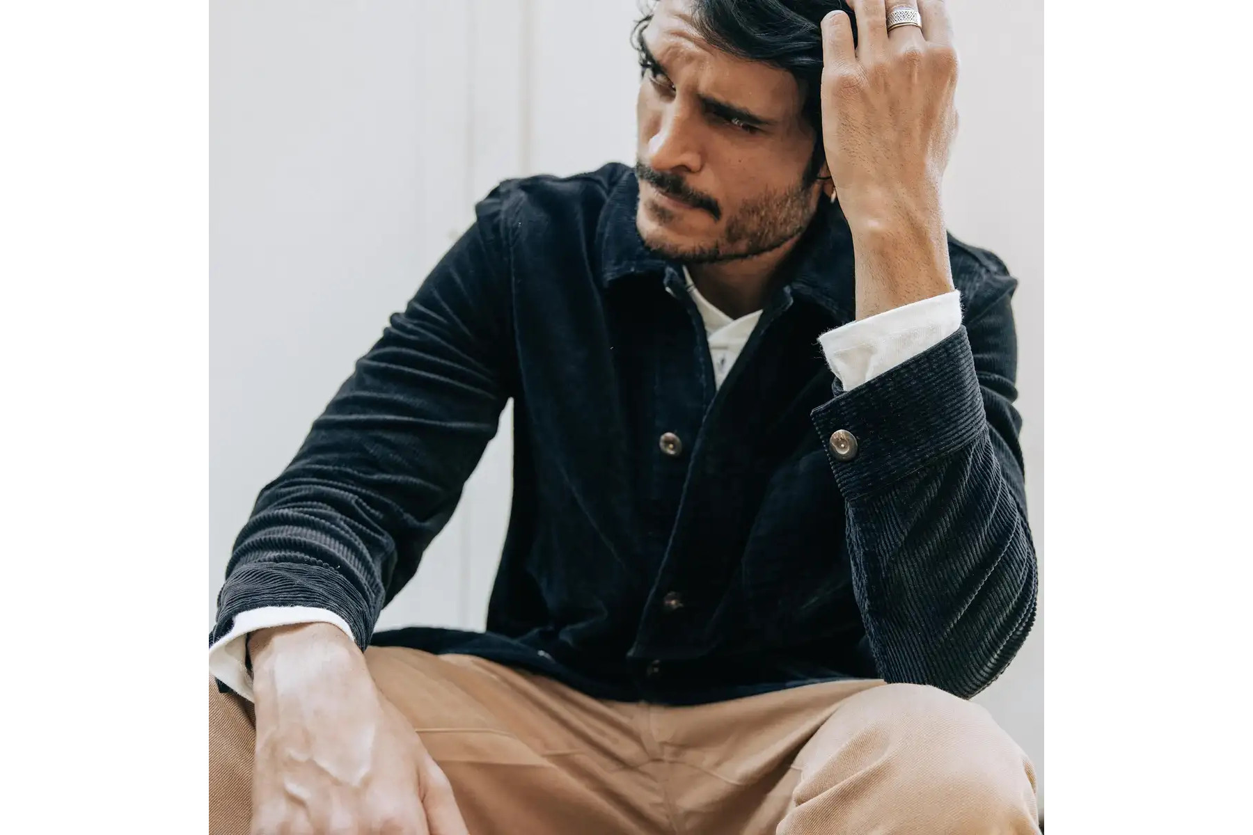 Man sitting in a green corduroy jacket.