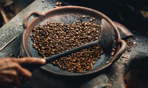Person roasting coffee beans in a wok