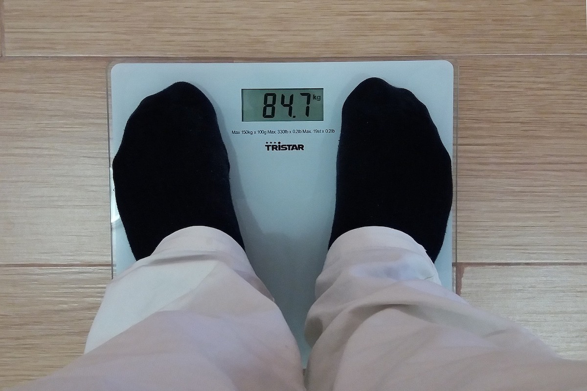 Man standing on a body fat scale.