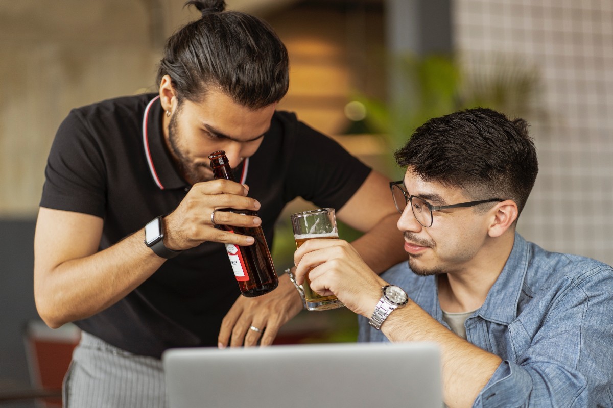 two men drinking beer at work