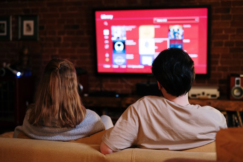 woman and man sitting on couch watching tv