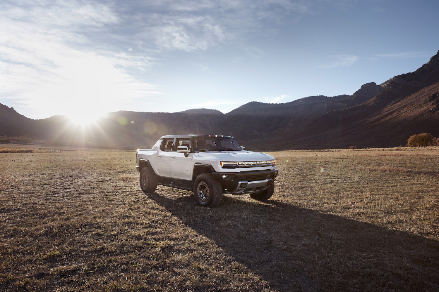 The 2022 GMC Hummer EV Pickup hits the desert with a mountain backdrop.