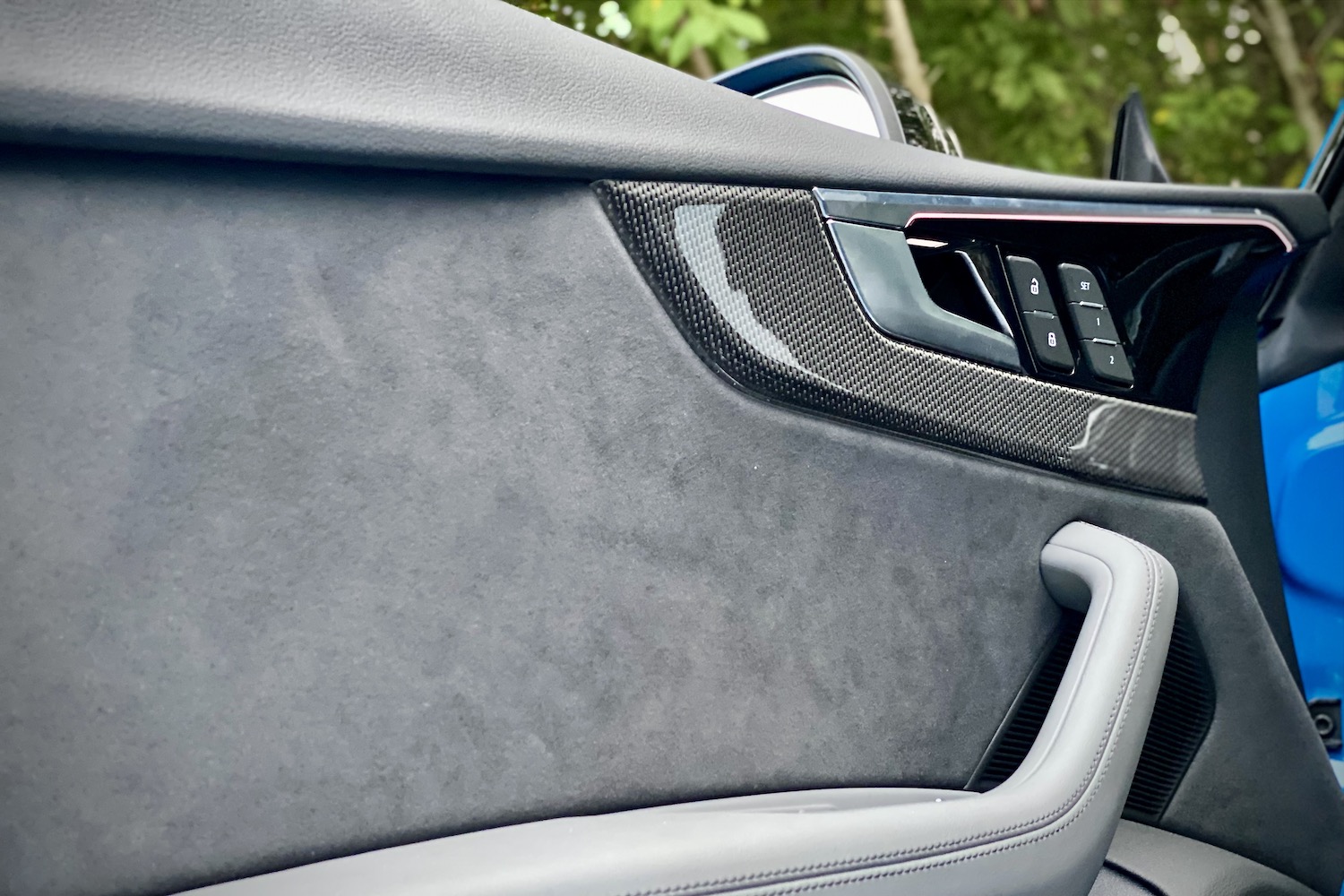 Close up of door trim in the 2023 Audi S5 Sportback with trees in the back.