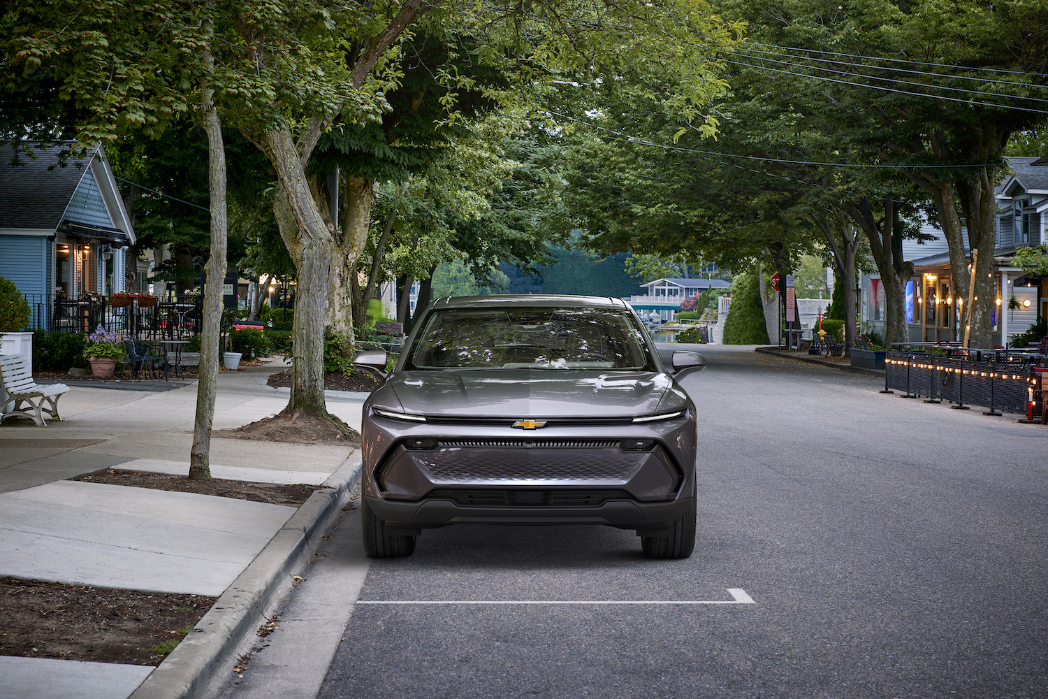 Front end of 2024 Chevrolet Equinox EV 1LT on a street with trees in the back.