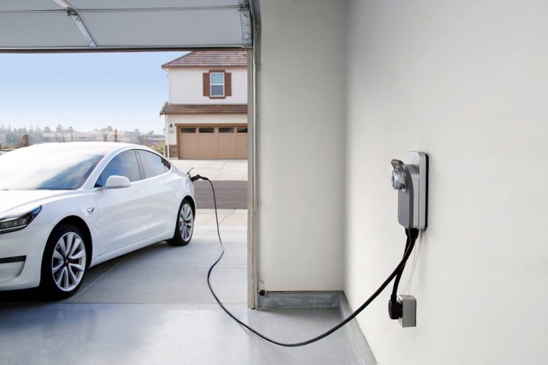 ChargePoint Home Flex EV charging station charging a white Tesla in a garage.