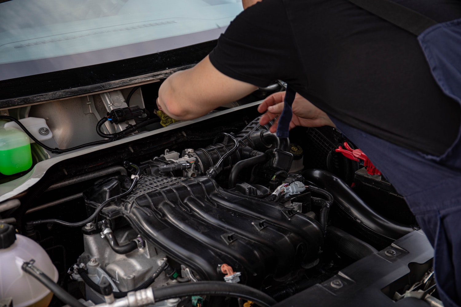 Mechanic looking at the engine compartment of a car.