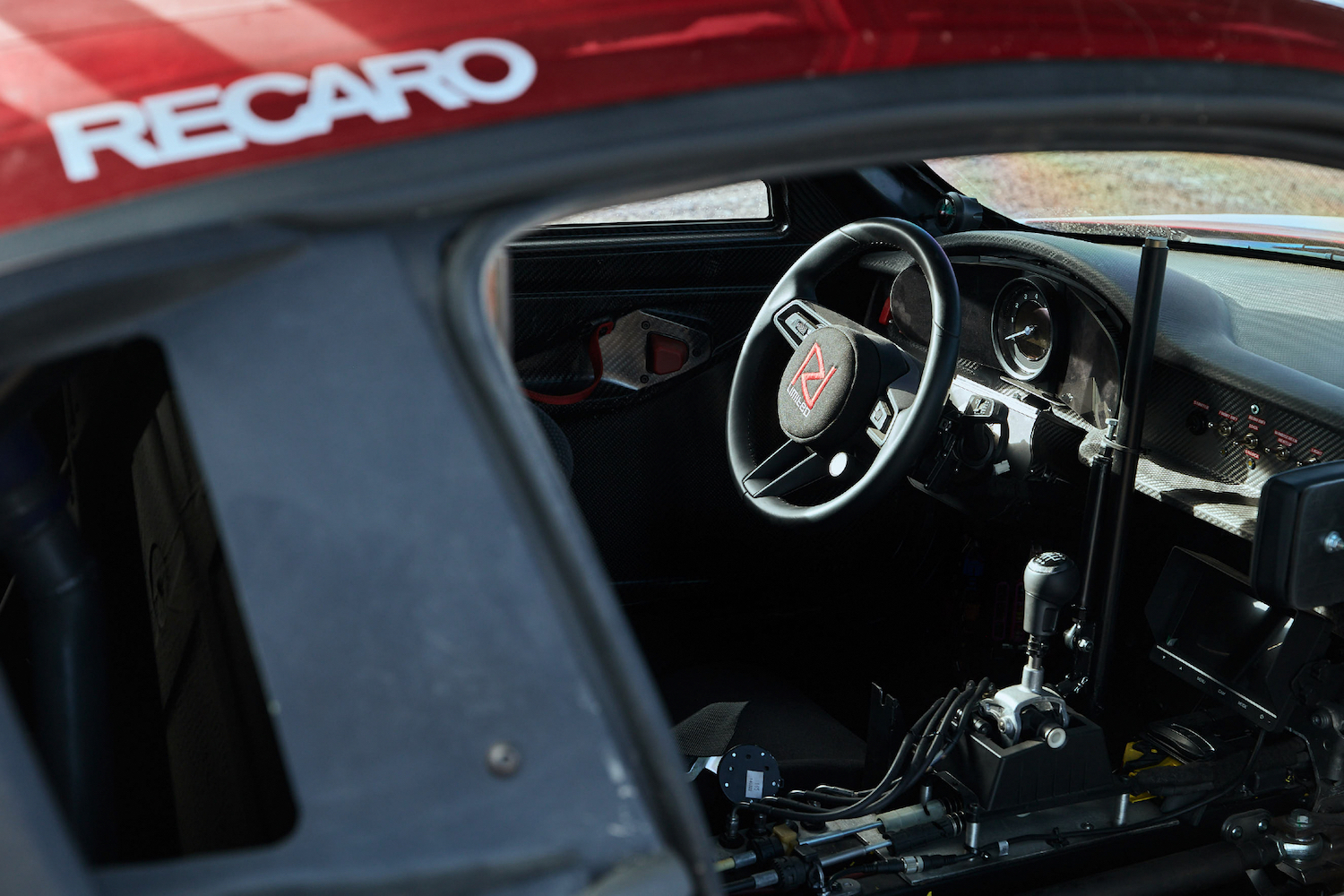 Close up of steering wheel and manual shifter from outside the car in Porsche 911 Dakar Prototype.