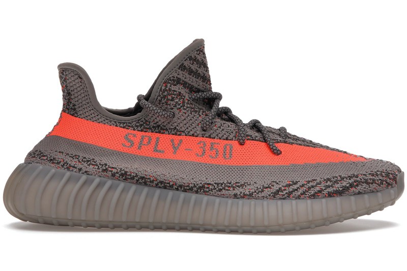 A pair of gray Yeezy sneakers with an orange stripe.
