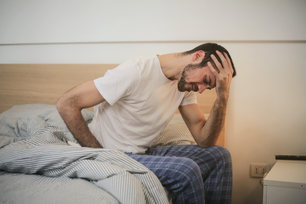 a man holding his back in bed
