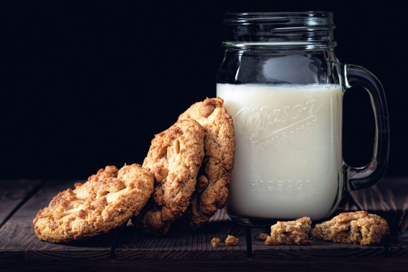 mason jar of milk next to a stack of cookies