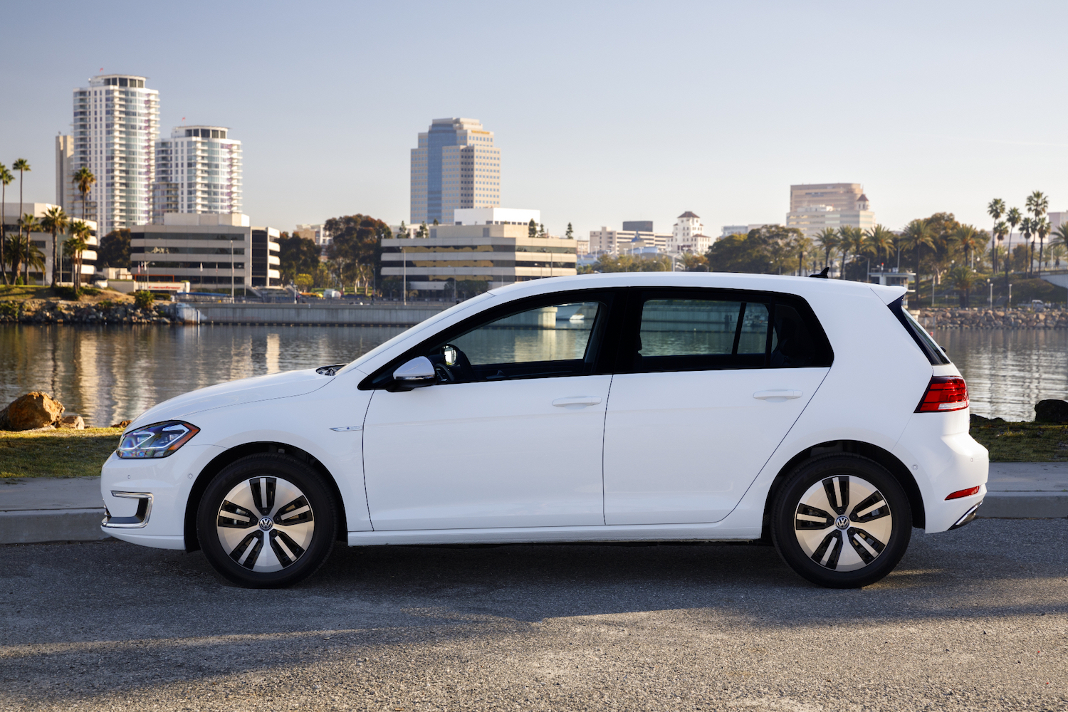Side profile of 2017 Volkswagen e-Golf parked in front of tall city buildings.