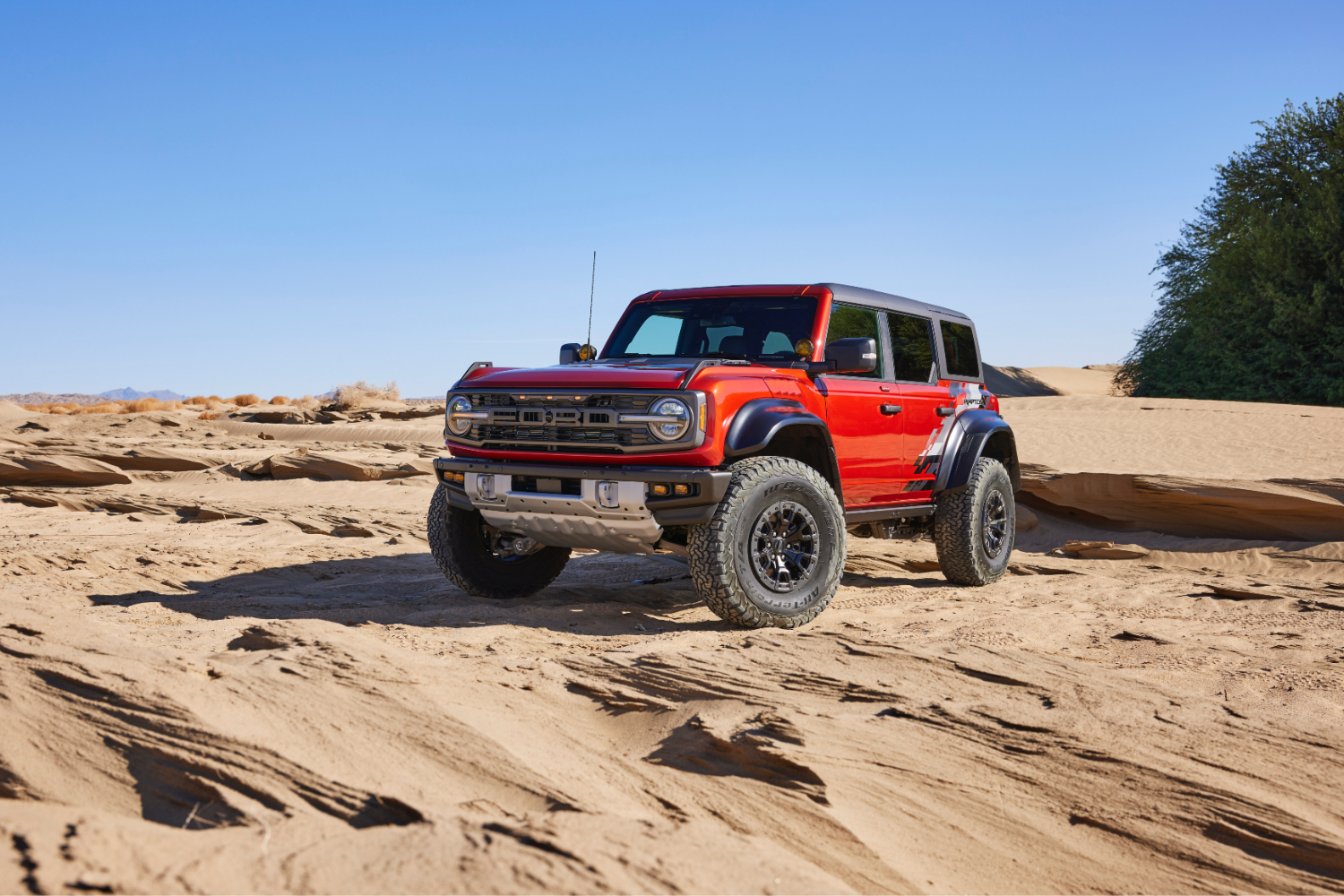 2022 A Ford Bronco Raptor elülső végszöge a vezető oldalától a homokdűnékben