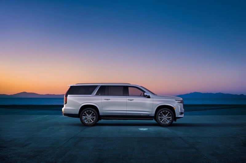 Side profile of 2023 Cadillac Escalade ESV in front of a mountain range at dawn.