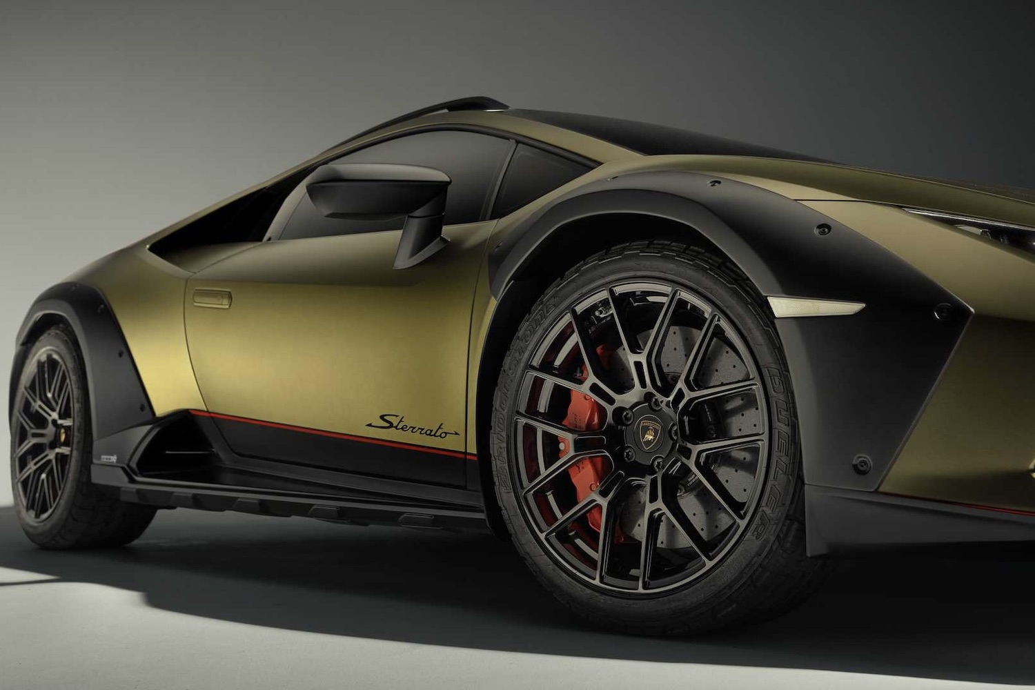 Close up of side wheels, tires, and fender flares on 2023 Lamborghini Huracan in a studio.