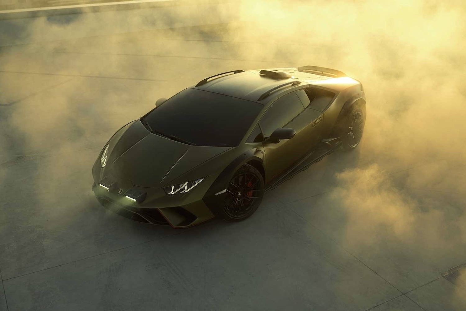 Front end angle of 2023 Lamborghini Huracan with smoke in the back on a rooftop during sunset.