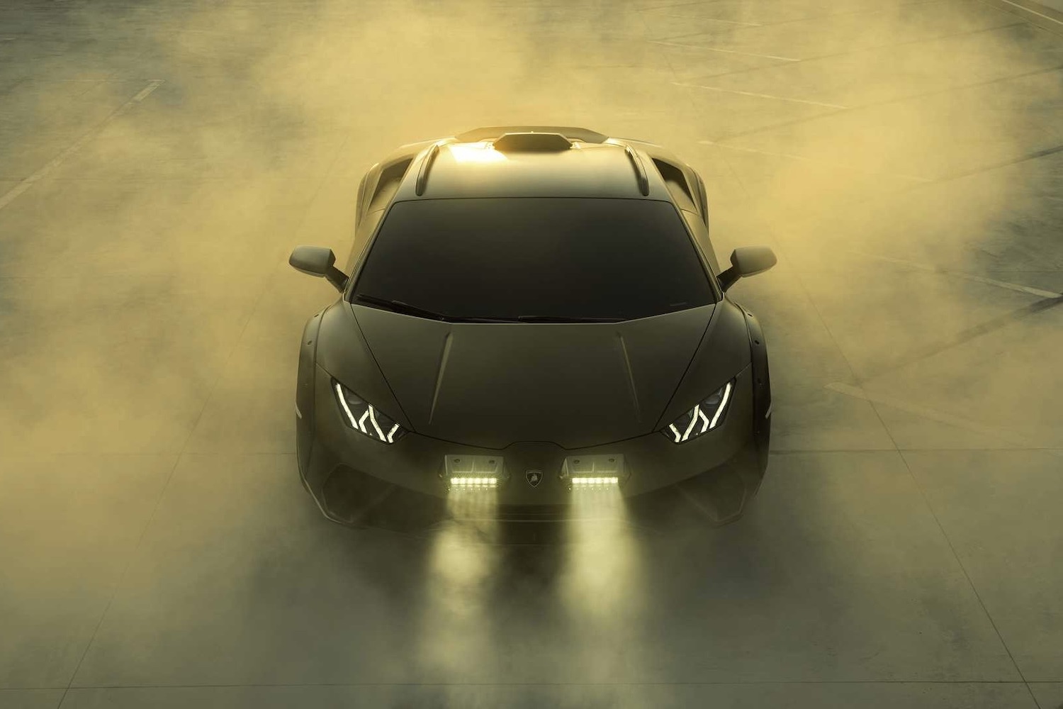 Front end close up of 2023 Lamborghini Huracan with smoke in the back with headlights on.