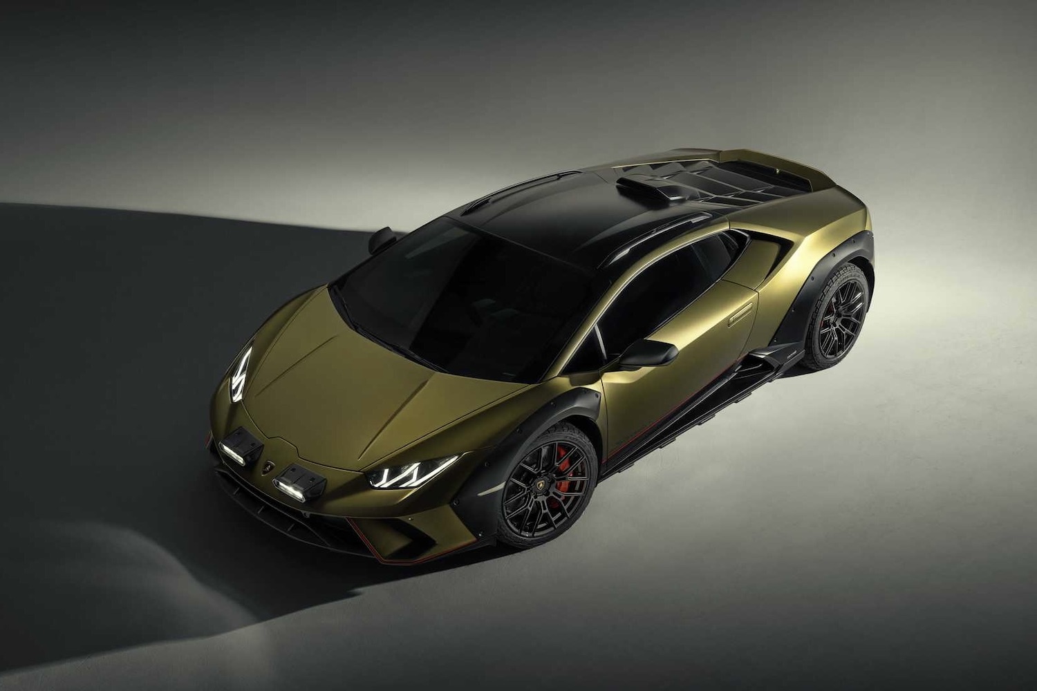 Front end angle from driver's side of the 2023 Lamborghini Huracan in a studio with dramatic lighting.