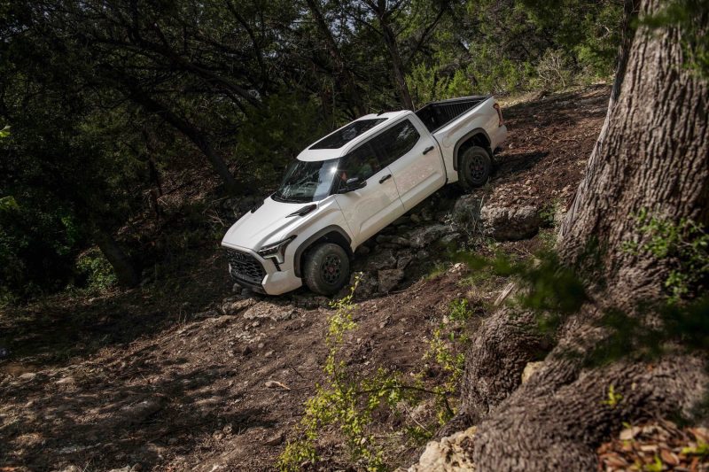 2023 Toyota Tundra TRD Pro front end from driver's side driving down a steep decline on a rough trail.
