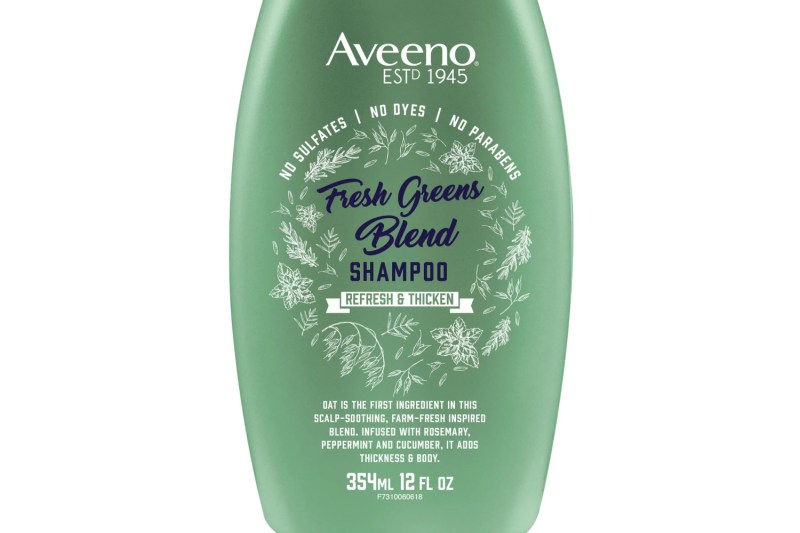A close-up of a bottle of Aveeno Scalp Soothing Fresh Greens Blend Shampoo