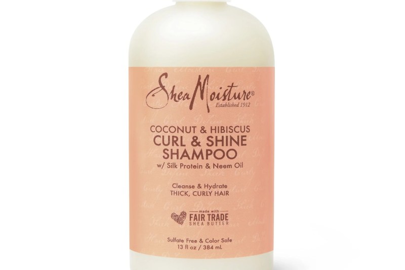 A close-up of a bottle of SheaMoisture Coconut and Hibiscus Curl and Shine Shampoo.