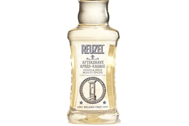 A close-up of a bottle of Reuzel Wood and Spice Aftershave.