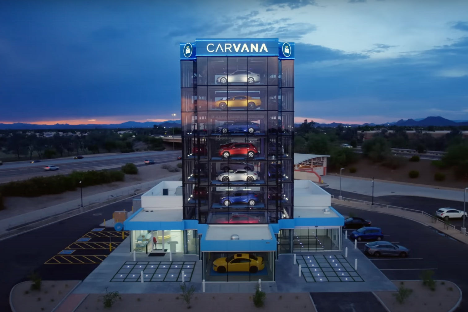 Exterior shot of Carvana Vending Machine during sunset with clouds in the back.