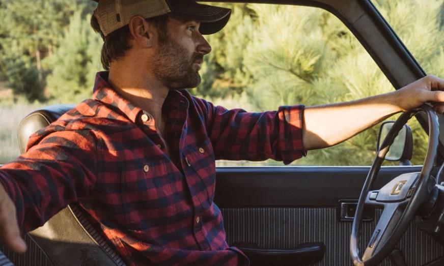 Man in a flannel shirt driving a truck