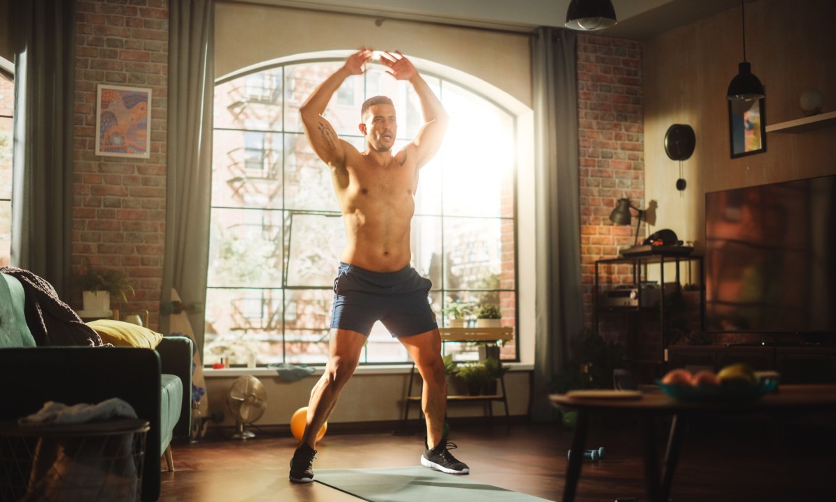 Man doing jumping jacks outside