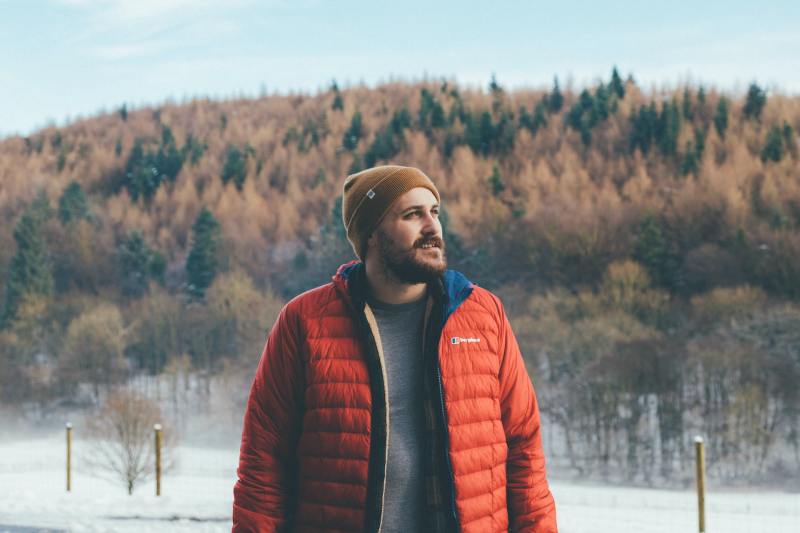 Man in a red puffer jacket standing outside in winter.