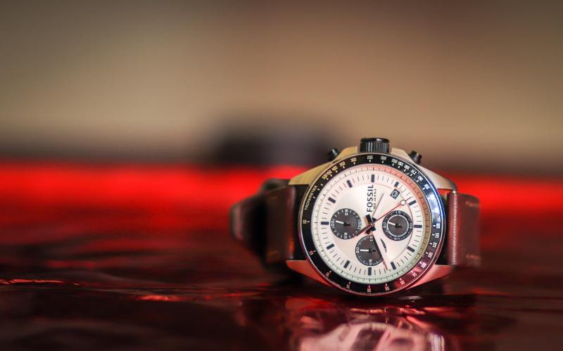 Metal watch on a reflective surface.