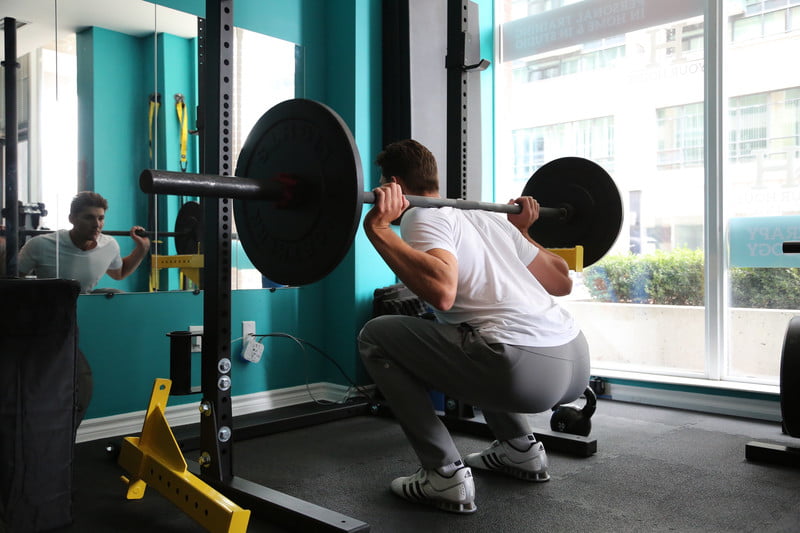 Man doing squats with a weight