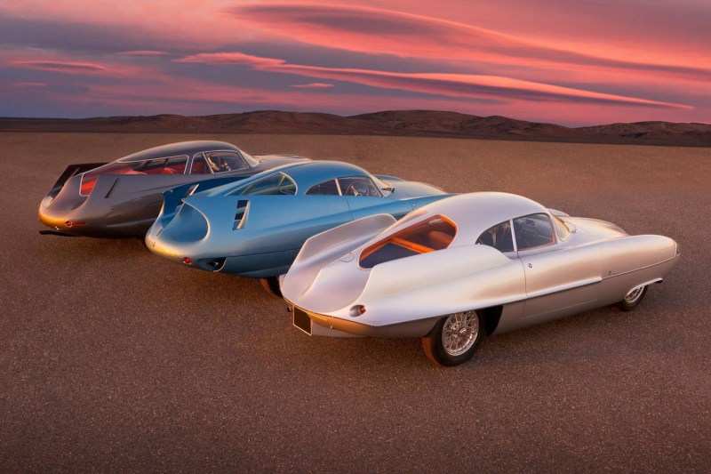 1953 Alfa Romeo Alfa BAT Cars ángulo trasero en un sendero de tierra frente a las montañas durante la puesta de sol.