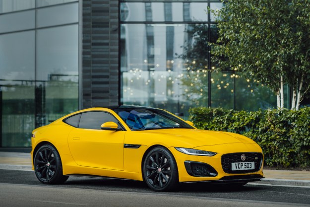 2022 Jaguar F-típusú elülső szög az utas oldalától az utca oldalán parkolt, a háttérben egy üvegépület