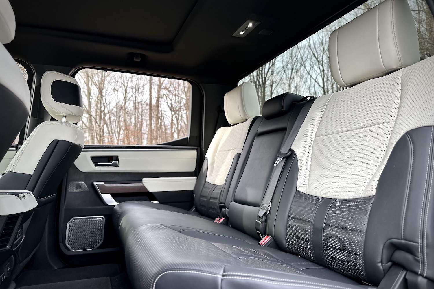 Rear seats in the 2022 Toyota Tundra Hybrid Capstone from outside the vehicle with trees in the background.