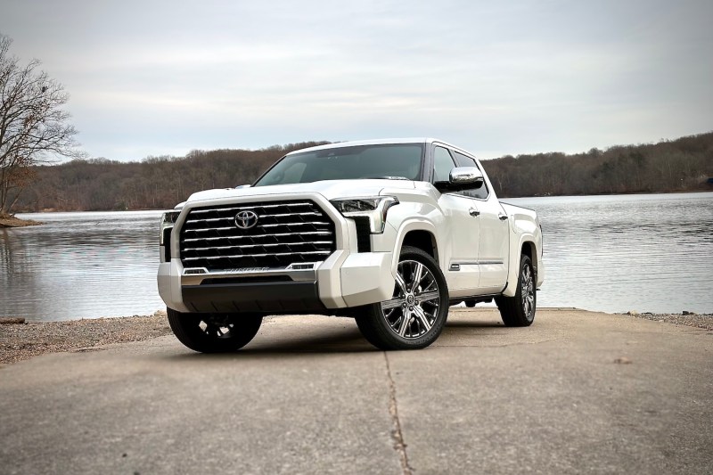 Front end angle of 2022 Toyota Tundra Hybrid Capstone from driver's side parked on a boat ramp with water in the background.