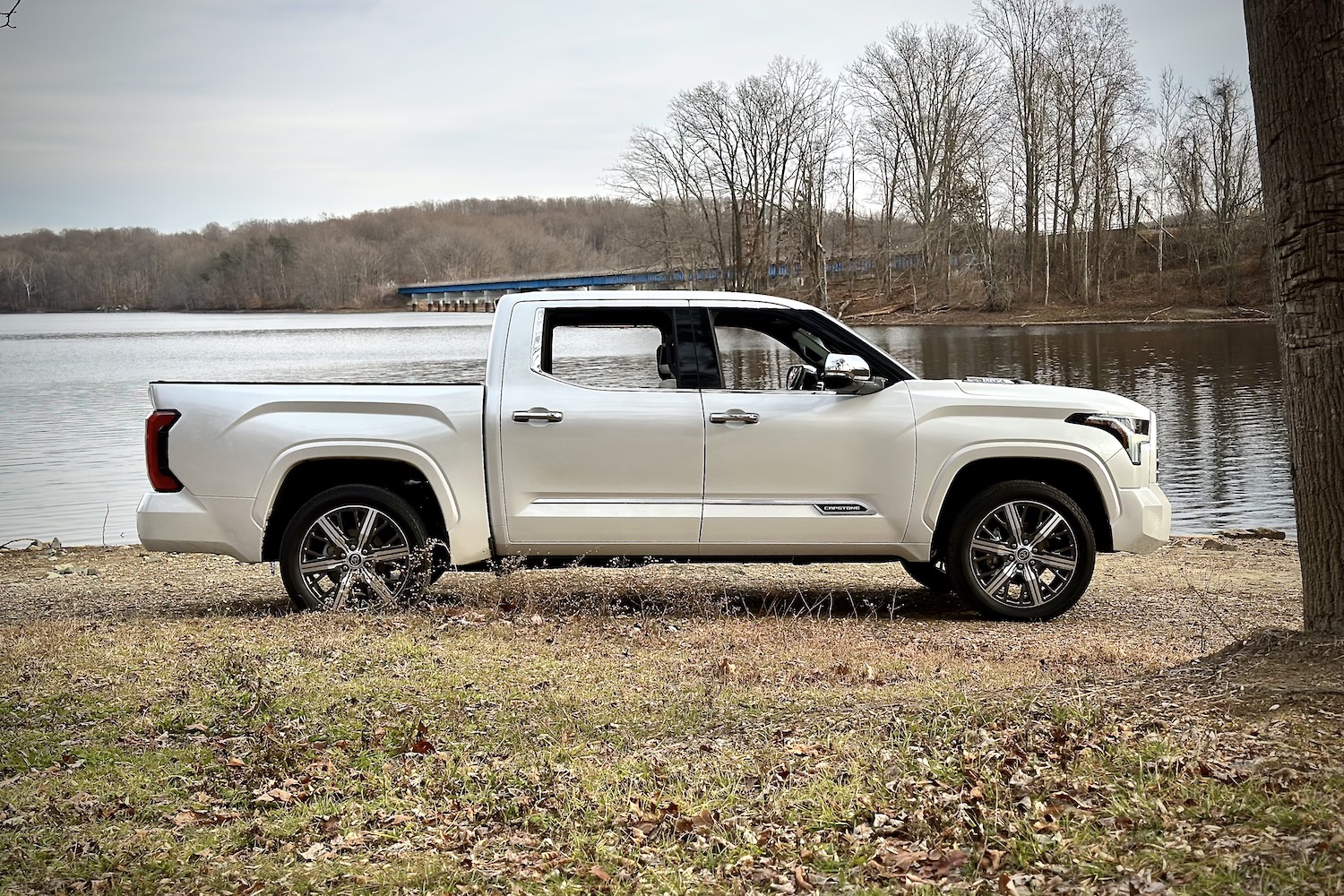 Side profile of 2022 Toyota Tundra Hybrid Capstone parked in front of a lake.