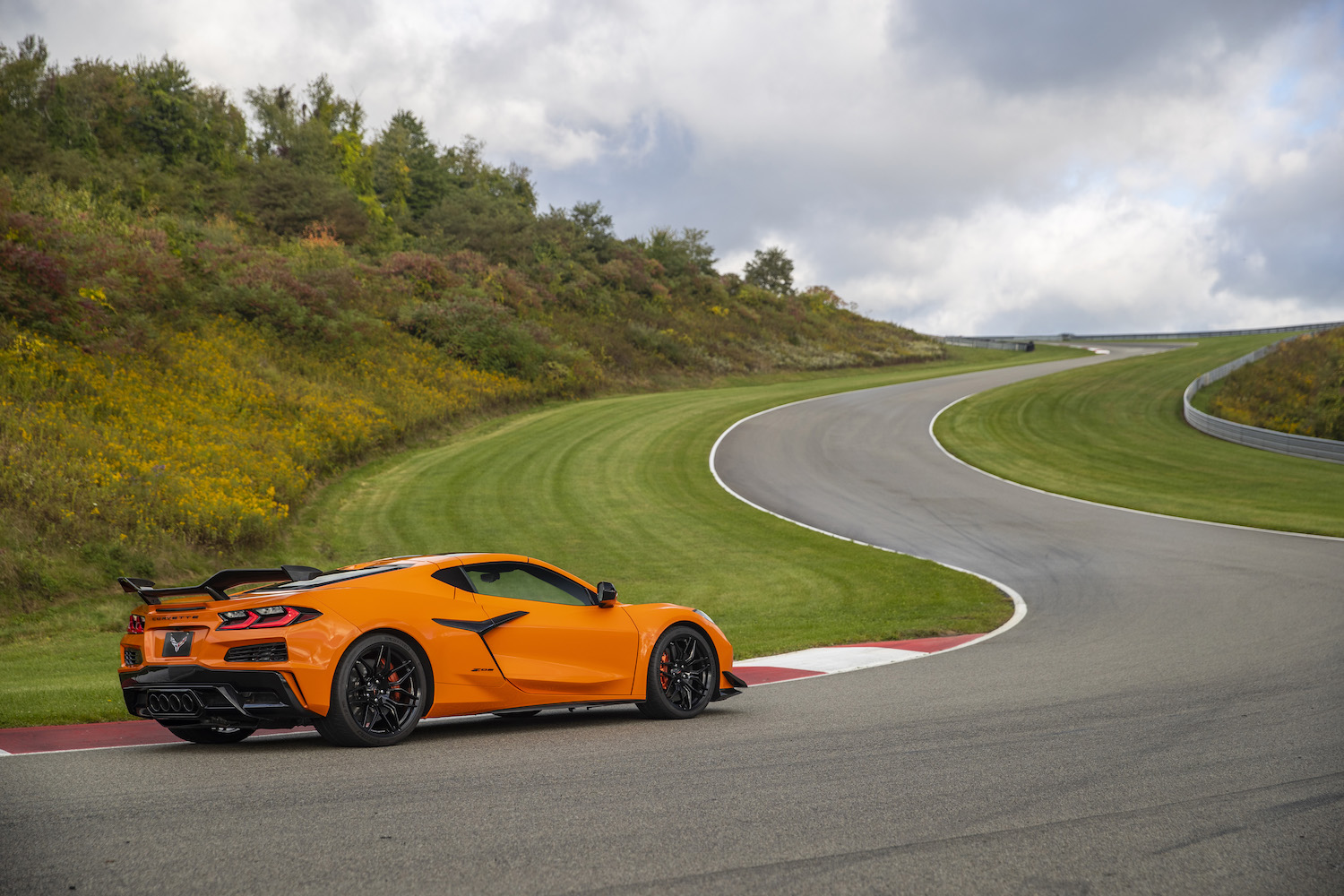 2023 Chevrolet Corvette Z06 rear end angle from passenger's side parked on a track with trees in the back.