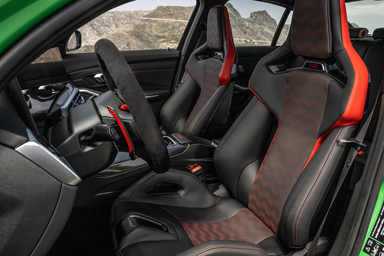 Close up of 2024 BMW M3 CS bucket seats from driver's side with mountains in the back.