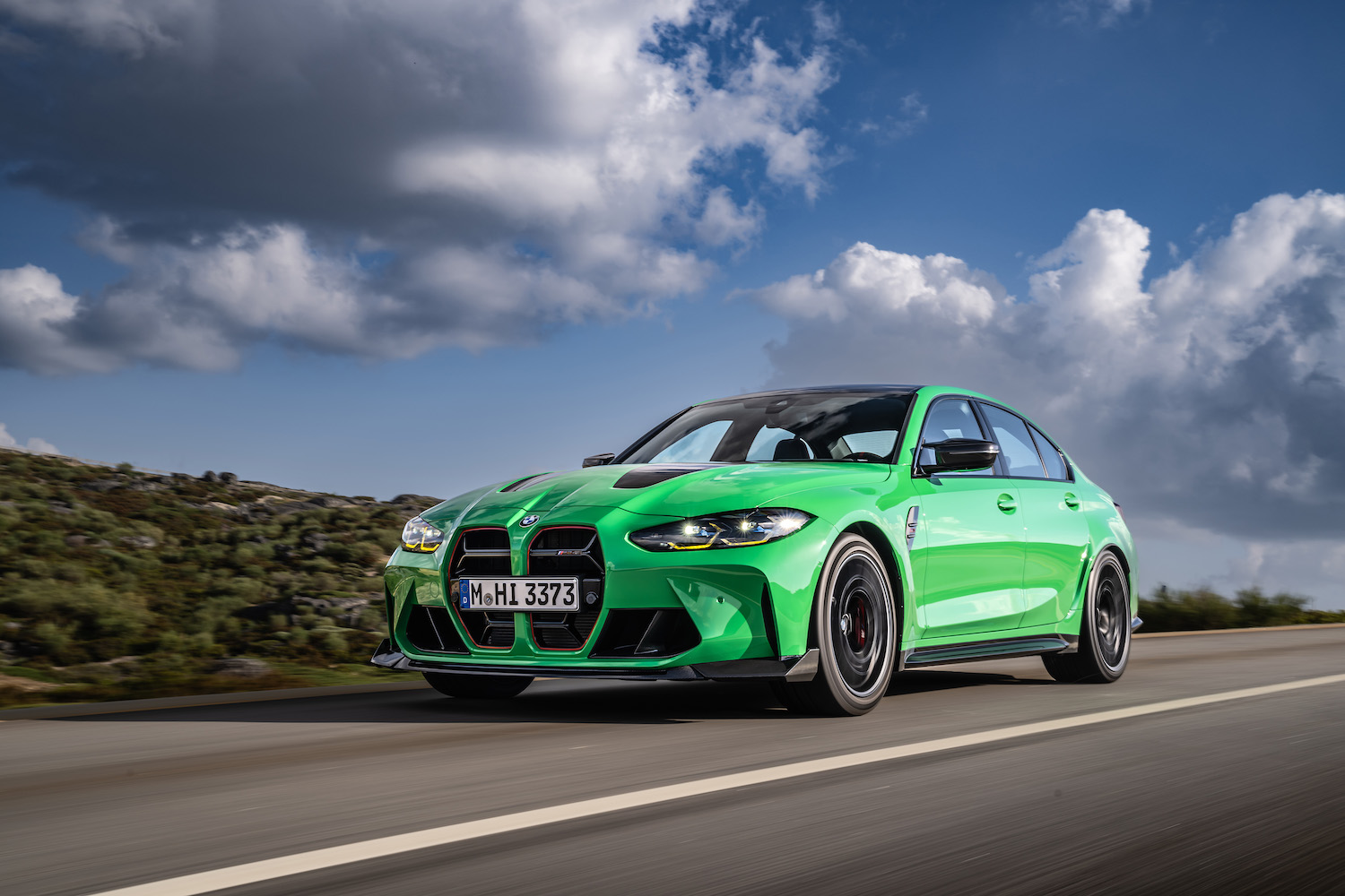 Front end angle of 2024 BMW M3 CS from driver's side with clouds in the back.